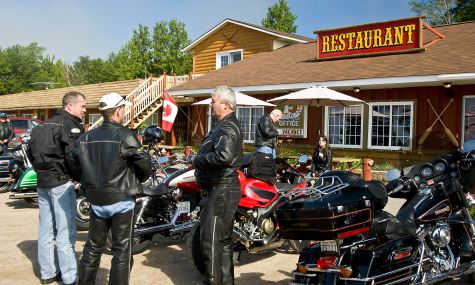 group of riders with motorcycles in front of restaurant